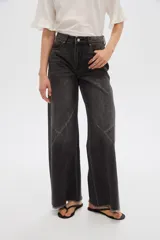 Pantalón jean gris de tiro alto, corte ancho (wide leg) con diseño de paneles tipo patchwork y terminación desmechada en el dobladillo.
