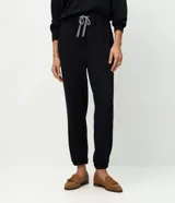 Pantalón tipo jogger de corte holgado con cintura elástica y cordón bicolor ajustable. Presenta puños elásticos en los tobillos y bolsillos laterales.