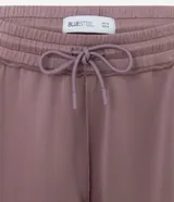 Pantalón de corte recto con cintura elástica y lazo de ajuste frontal. Confeccionado en tejido modal con caída fluida y estructura cómoda.