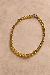 Collar de piedras semipreciosas facetadas en tono ámbar, con cierre metálico con baño de oro 18k.