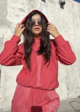 Conjunto deportivo de dos piezas en color rojo, compuesto por un buzo corto con capucha y un pantalón de jogging con cintura elástica.