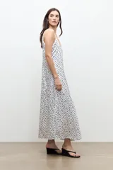 Vestido largo de color crudo con estampado de lunares negros, escote en V y tirantes finos.