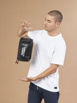 Neceser azul con cierre superior y correa de mano. Estampado con el logo "Benson & Thomas" en el frente.