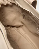 Cartera tote color taupe de símil cuero con tiras de hombro estampadas con la marca y detalle de logo circular en el frente.