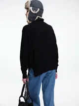 Sweater de cuello polera con hombros caídos y diseño de calce holgado. Presenta terminaciones acanaladas en puños y ruedo, confeccionado en tejido de punto suave.