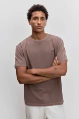 Remera de algodón color marrón con efecto lavado, de corte clásico y cuello redondo. Presenta un pequeño bordado de un pájaro en el pecho.