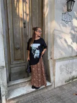 Conjunto compuesto por un remerón negro de algodón con estampa fotográfica frontal y una pollera midi de satén con estampado animal print de leopardo.