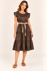 Vestido midi marrón con diseño de capas escalonadas en la falda, mangas cortas con hombros estructurados y cuello redondo. Incluye un cinturón de tela a rayas en la cintura.