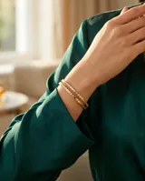 Pulsera esclava de acero con baño de oro, compuesta por una hilera de circonias engarzadas en bisel.