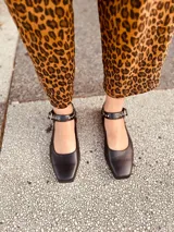 Zapato tipo Mary Jane color negro, con correa al tobillo con hebilla y detalles de tachas plateadas.