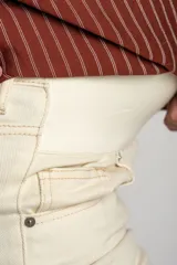 Pantalón de jean color beige, de corte wide leg con botamanga desflecada y tiro medio, diseñado especialmente para maternidad.