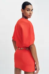 Falda corta de punto con cintura elástica y diseño en evasé de color rojo.