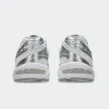 Championes Asics modelo Gel 1130, color blanco con detalles plateados y verde oscuro. Diseño retro inspirando en el running con tecnología GEL en el talón.