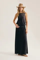 Maxi vestido negro sin mangas, con cuello redondo y silueta suelta que se abre en A hacia el ruedo. Confeccionado en 100% algodón, incluye aplique trasero en forma de X.