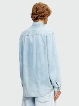Camisa de jean celeste claro Diesel modelo D-Simply, de corte recto, manga larga, cuello clásico y cierre frontal con botones metálicos. Presenta un pequeño logo rojo bordado en el pecho.