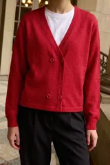 Cardigan tejido de punto con hilo lurex, color rojo, con cuello en V, diseño cruzado y cierre frontal con cuatro botones en forma de flor.