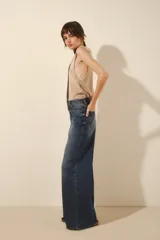 Jean de corte oxford y tiro medio, confeccionado en denim de color azul clásico. Presenta un diseño de pierna ancha y holgada, con cierre frontal y bolsillos laterales y traseros.