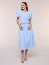 Falda midi abotonada de textura gofrada y diseño a rayas. Presenta cintura ancha entallada, abotonadura frontal completa, corte con frunce para mayor amplitud y bolsillos laterales funcionales. Cuenta con forro interno.