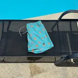 Short de baño negro con estampado de rodajas de naranja, cintura elástica con cordón ajustable y logo circular en el ruedo.