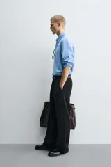 Pantalón de corte wide fit confeccionado en pana de algodón color marrón oscuro. Presenta bolsillos frontales, bolsillos traseros de vivo con botón y cierre frontal con cremallera y botón.