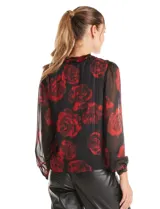 Blusa de gasa con estampado floral en tonos rojos sobre fondo negro. Presenta escote en V, mangas largas traslúcidas con puños ajustados y detalles de fruncido en los hombros.
