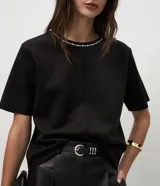 Remera de corte regular confeccionada en gamuza sintética color negro, con mangas cortas y cuello redondo decorado con una aplicación de pedrería brillante.