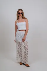 Falda larga blanca de encaje con diseño floral transparente y forro corto interior.