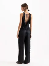 Pantalón palazzo de tiro alto color negro, confeccionado en twill de viscosa con caída fluida. Cuenta con cintura clásica con presillas, pinzas frontales, bolsillos laterales y una delicada aplicación de puntilla de encaje a lo largo de ambos laterales.