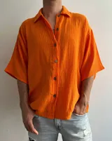 Sobrecamisa naranja de muselina, corte unisex, con cuello camisero, manga 3/4 y cierre frontal con botones.