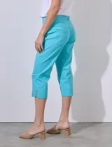 Pantalón capri de gabardina elastizada color celeste, con bolsillos simulados delanteros y bolsillos aplicados traseros. Tiene pretina ancha, corte recto y detalle calado en el ruedo.