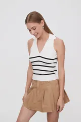 Top blanco de tejido de punto acanalado, sin mangas, con cuello polo y rayas horizontales negras.