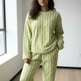 Conjunto de pijama de dos piezas confeccionado en plush texturado con diseño de ochos. Incluye un buzo de cuello redondo y manga larga, y un pantalón a juego. Material suave y cálido ideal para el invierno.