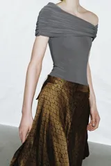 Body azul marino de escote asimétrico con un hombro descubierto, detalle de frunces en el busto y cierre de botones a presión en la parte inferior.