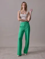 Pantalón naranja de crepe elastizado, corte recto, con bolsillos delanteros y apliques de botones metálicos.