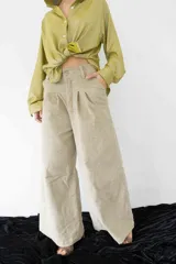 Pantalón de tiro alto con corte amplio y recto, presenta pinzas en la cintura y bolsillos laterales. Confeccionado en tela liviana de textura natural con caída suelta.