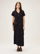 Vestido midi de morley color negro, con escote en V, mangas cortas y diseño con volados asimétricos en el lateral inferior.