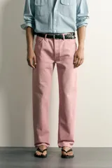 Jeans straight fit de denim de algodón color rosado, con diseño de cinco bolsillos, tiro medio y corte de pierna recta desde la cadera hasta el tobillo. Cuenta con cierre frontal de cremallera y botón metálico.