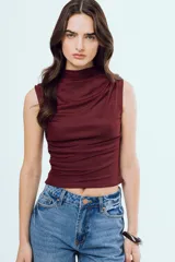 Top Bonnie negro sin mangas, con cuello alto y diseño ajustado con fruncidos laterales.