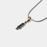 Conjunto compuesto por una cadena de eslabones de plata con detalles en oro y un dije colgante con forma de niña en plata.