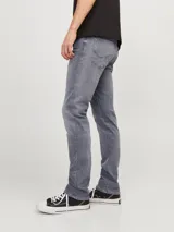 Jean de corte ajustado y tiro bajo, confeccionado en denim gris con acabado lavado. Cuenta con diseño clásico de cinco bolsillos y cierre frontal con botón.