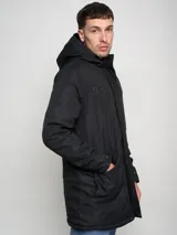 Parka larga gris con capucha, cierre frontal con cremallera y botones a presión, múltiples bolsillos y logo de Umbro en el pecho.