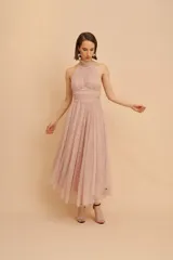 Vestido midi de fiesta confeccionado en microtul, color rosado, con diseño sin mangas, cuello halter fruncido y falda con vuelo de largo midi.