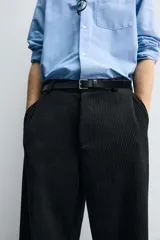 Pantalón de corte wide fit confeccionado en pana de algodón color marrón oscuro. Presenta bolsillos frontales, bolsillos traseros de vivo con botón y cierre frontal con cremallera y botón.