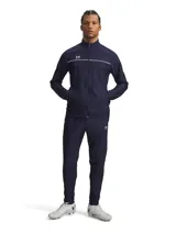 Conjunto deportivo Under Armour Challenger compuesto por una chaqueta con cierre frontal y bolsillos laterales, y un pantalón con cintura elástica y cordón interno. Ambas piezas presentan un diseño en color azul marino con detalles de líneas blancas y el logo de la marca.