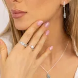 Aros colgantes de plata 925 con tres pequeñas piedras de la luna y una piedra de topacio azul ovalada.