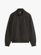 Campera tipo Harrington de Tommy Hilfiger en color negro, de corte amplio y tejido repelente al agua. Cuenta con cuello levantado, cierre frontal de cremallera con botón, bolsillos de ojal en la cintura, y puños y bajo de punto canalé. Presenta el logo de la marca bordado en el pecho.