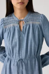 Vestido midi de color azul, con diseño de volados en la falda, mangas largas con puños, escote con cordón ajustable y detalle de bordado en la parte superior.