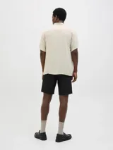 Camisa de manga corta con cuello resort, confeccionada en viscosa fluida con cierre frontal de botones y corte relajado.