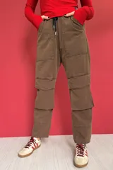 Pantalón cargo color marrón con cintura elástica ajustable con cordón, bolsillos laterales y bolsillos tipo parche con solapa en las piernas.