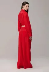 Pantalón wide-leg de organza en color rojo, con transparencia sutil y short interno incorporado. Presenta un diseño de tiro alto con lazo ajustable en la cintura y caída fluida.